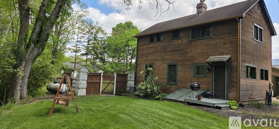 A wooden house with a green lawn in front.