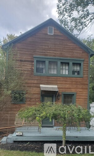 A wooden house with a tree in front of it.