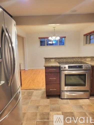 A kitchen with a stainless steel refrigerator and a stainless steel oven with a tile backsplash.
