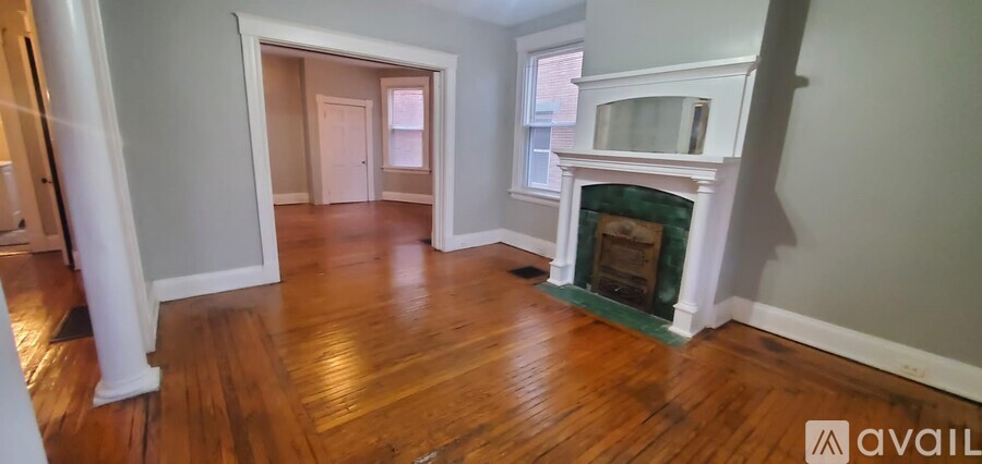 A living room with a fireplace and wood floors.