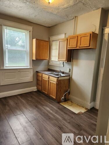 A kitchen with wooden cabinets and a window.