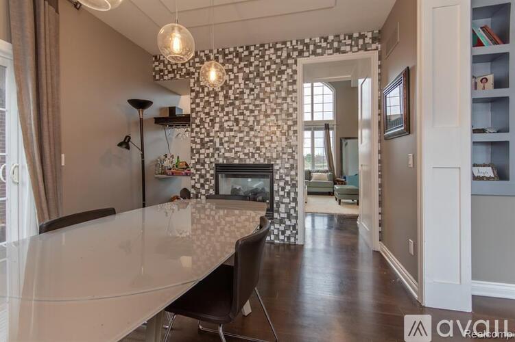 A modern dining room with a glass table and chairs.