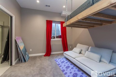 A living room with a white couch and a bunk bed.