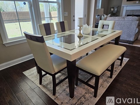 A modern dining room with a glass table and chairs.