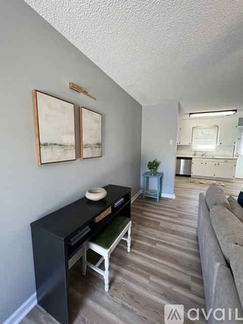 A living room with a grey couch and a black cabinet.