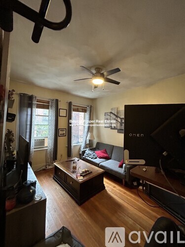 A living room with a couch, coffee table, and television.