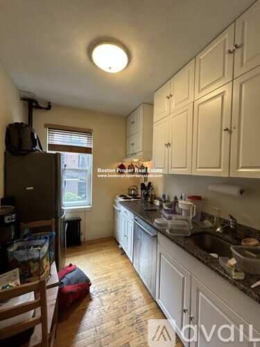 A kitchen with wooden floors and white cabinets.