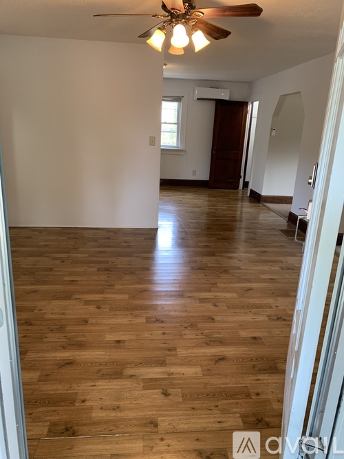A room with wooden flooring and a ceiling fan.