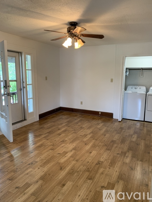 A room with wooden flooring and a ceiling fan.