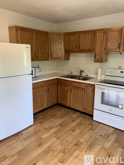 A kitchen with wooden cabinets and a white refrigerator.