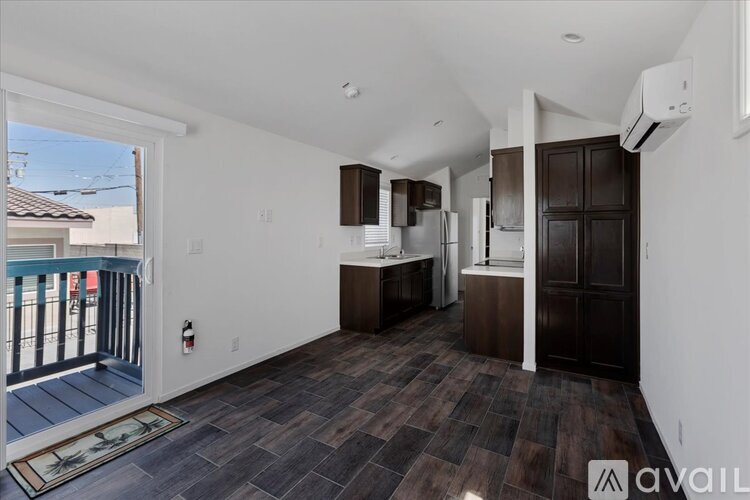 A kitchen area with a refrigerator, cabinets, and a countertop.