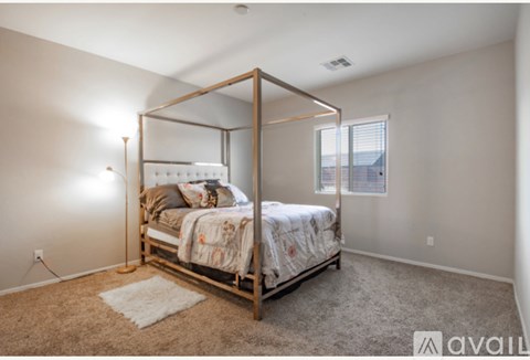 A bedroom with a four-poster bed and a carpeted floor.