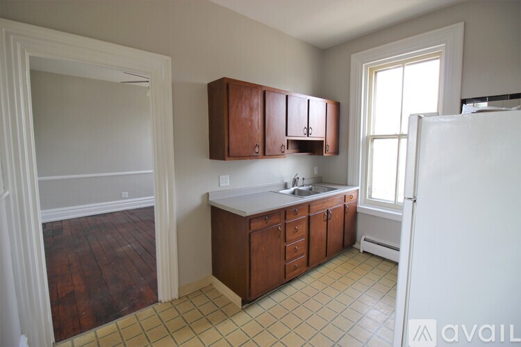 A kitchen with brown cabinets and a white fridge.