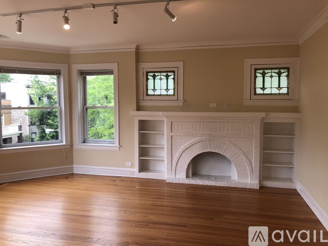 A living room with a fireplace and two windows.