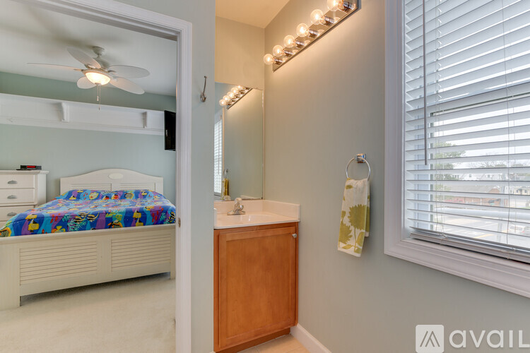 A bedroom with a bed, dresser, and window with blinds.