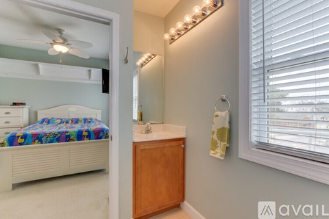 A bedroom with a bed, dresser, and window with blinds.