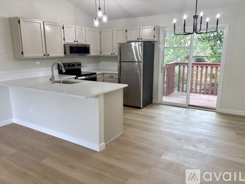 A kitchen with white cabinets and a wooden floor.