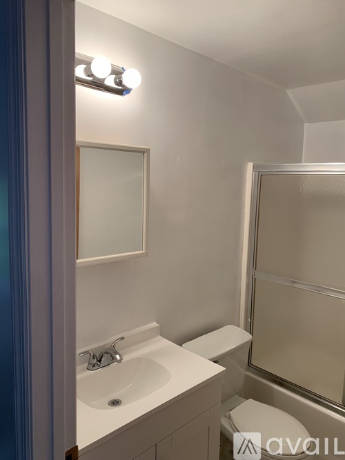 A bathroom with a sink, mirror, and toilet.