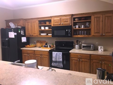 A kitchen with wooden cabinets and black appliances.