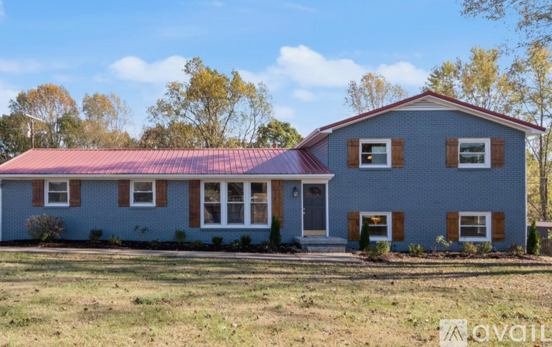 A house with a red roof and a blue exterior is for sale.