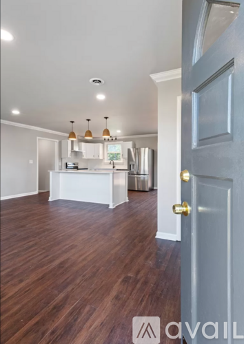 A kitchen with a white counter and a wooden floor.