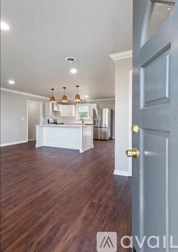 A kitchen with a white counter and a wooden floor.