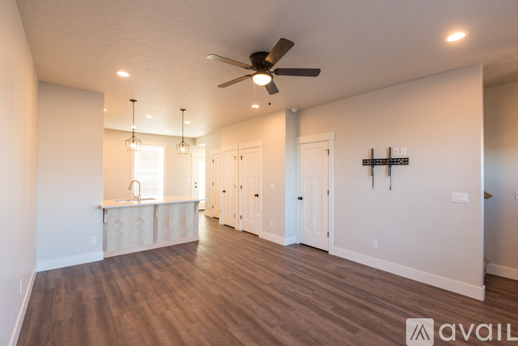 A spacious room with a ceiling fan and wooden flooring.