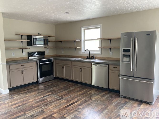 A kitchen with wooden floors and stainless steel appliances.