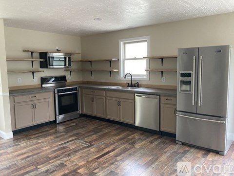 A kitchen with wooden floors and stainless steel appliances.
