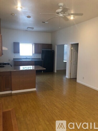 A kitchen with wooden floors and a ceiling fan.