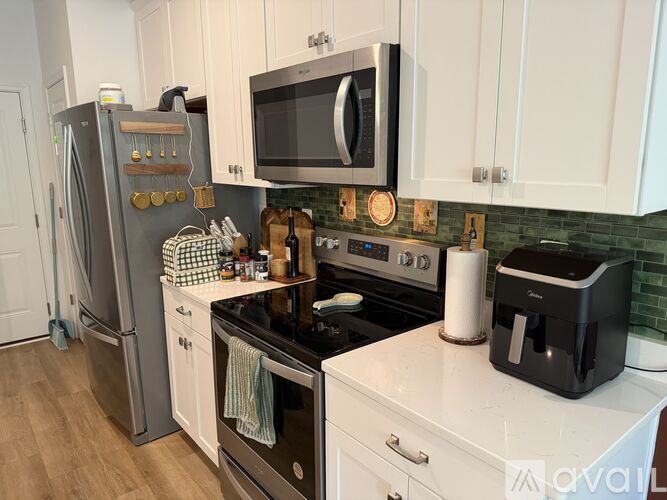 A kitchen with a black stove top and white cabinets.
