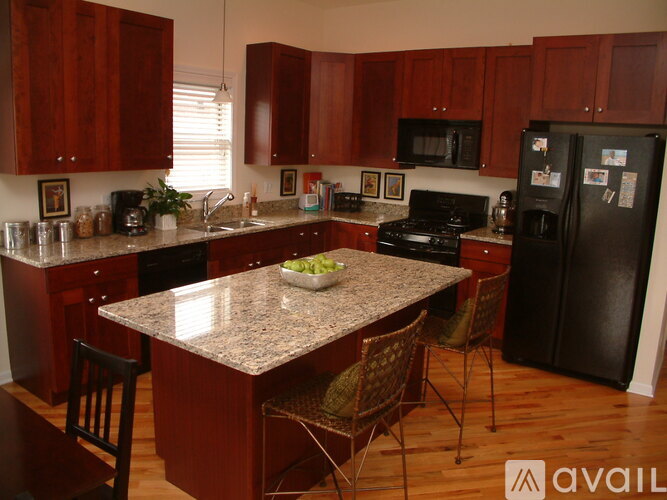 A kitchen with brown cabinets and a granite countertop.