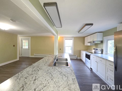 A kitchen with a granite countertop and white cabinets.