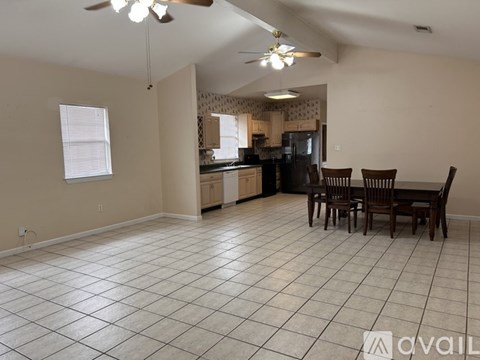 A kitchen with a dining table and chairs in the foreground.