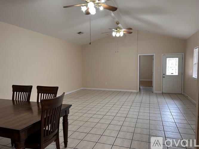 A room with a table and chairs and a ceiling fan.
