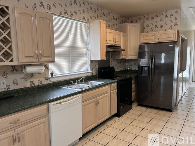 A kitchen with wooden cabinets and black appliances.