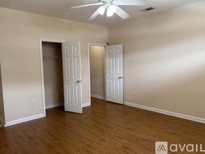 A room with a ceiling fan and two doors.