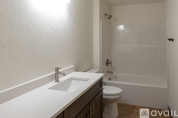 A bathroom with a white sink and toilet.