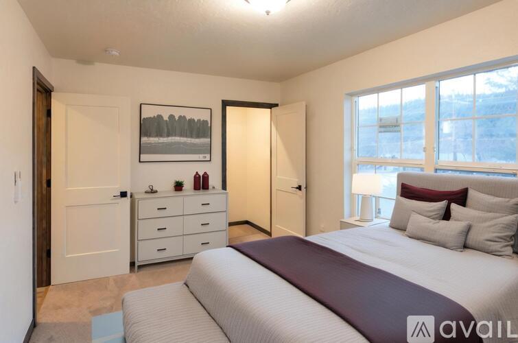 A bedroom with a large bed and a picture on the wall.