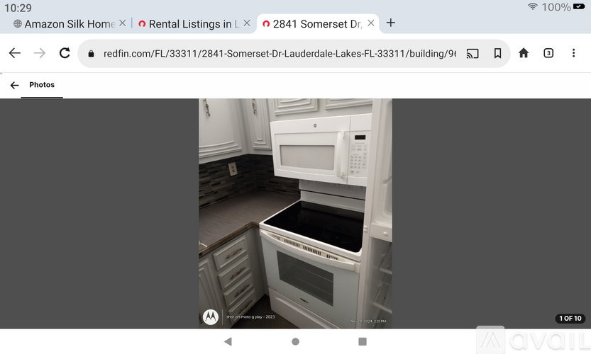 A white microwave oven is placed above a white dishwasher in a kitchen.
