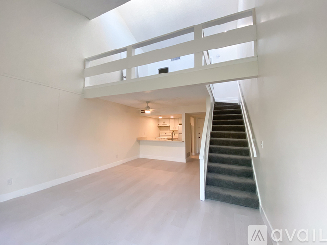 A spacious room with a staircase leading to the upper floor.