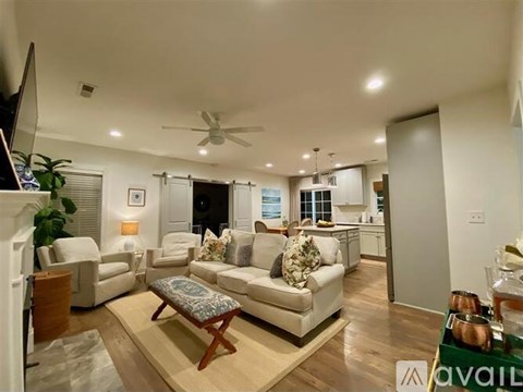 A living room with a white couch and a wooden coffee table.