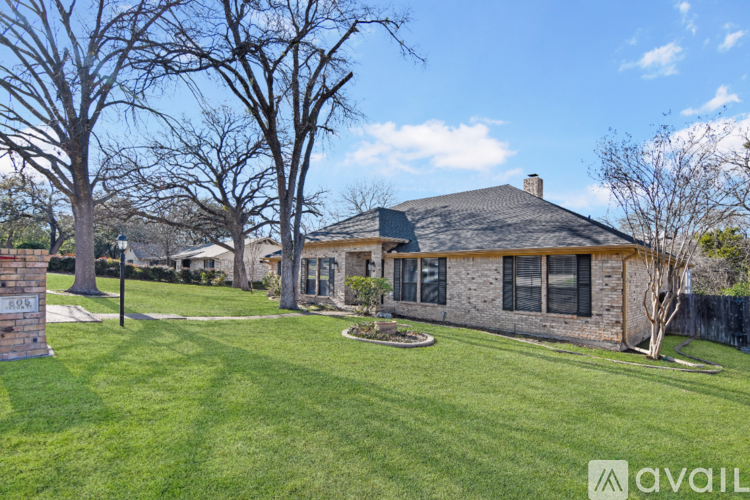A house with a lawn and trees in front of it.