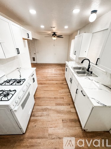 A kitchen with white cabinets and a white gas stove.