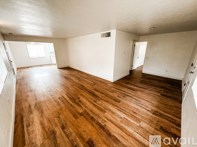 A room with wooden flooring and white walls.