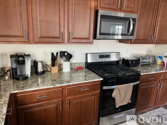 A kitchen with a black stove top oven and a microwave above it.