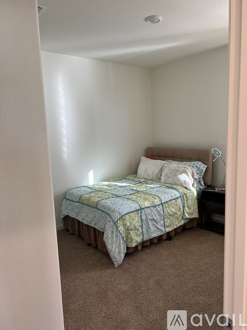 A bedroom with a bed and a nightstand.