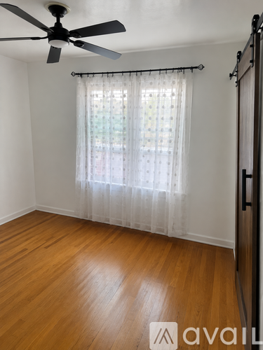 A room with wooden flooring and a large window.