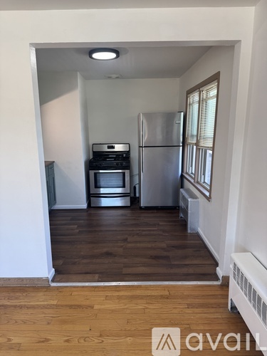 A kitchen with a refrigerator, oven, and microwave.