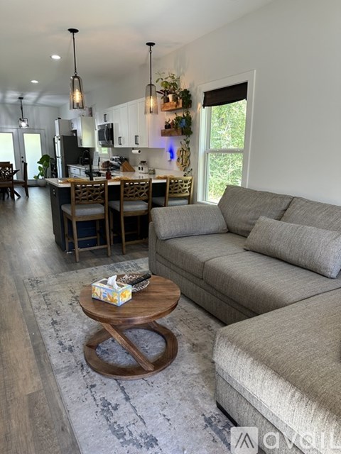 A modern living room with a grey sofa and a wooden coffee table.
